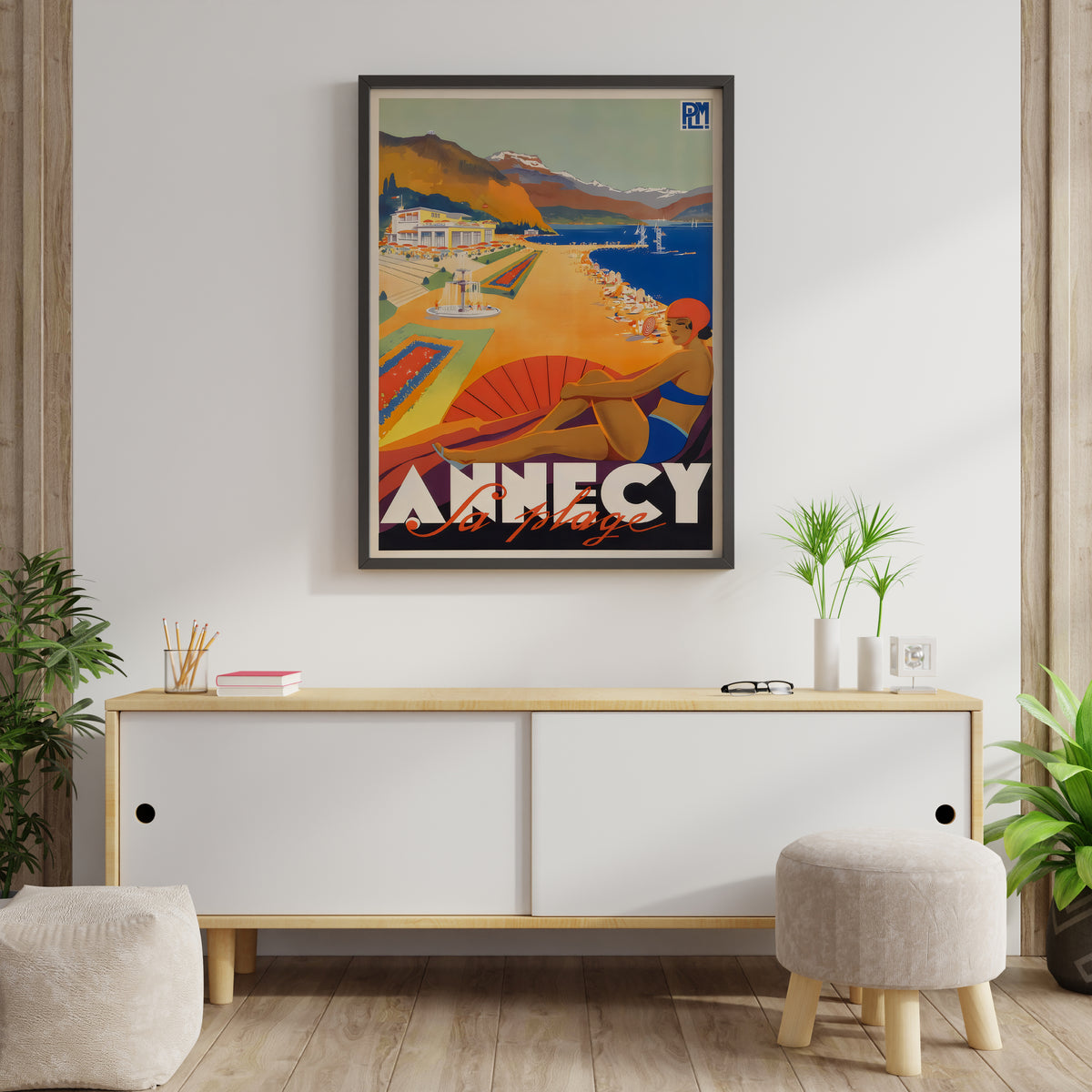 Vintage-style Annecy beach poster with a mountain lake and bold lettering, displayed in a living room