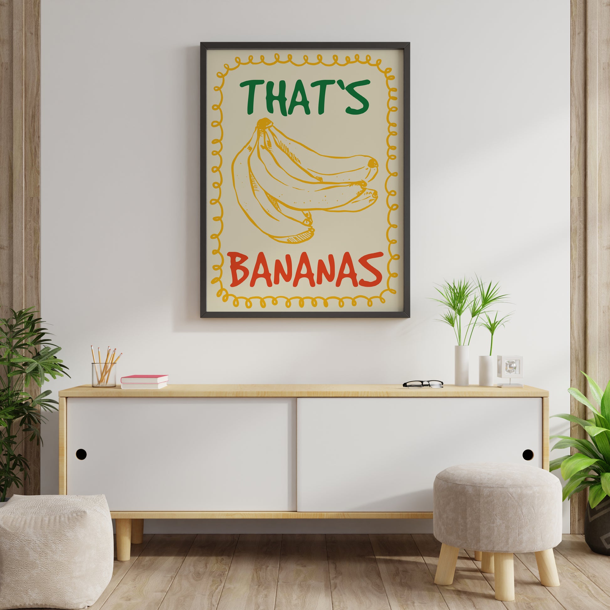 Vintage inspired banana art print in minimalist retro style with golden yellow banana sketch, green “THAT’S” and red “BANANAS” lettering framed by a curly yellow border on cream.