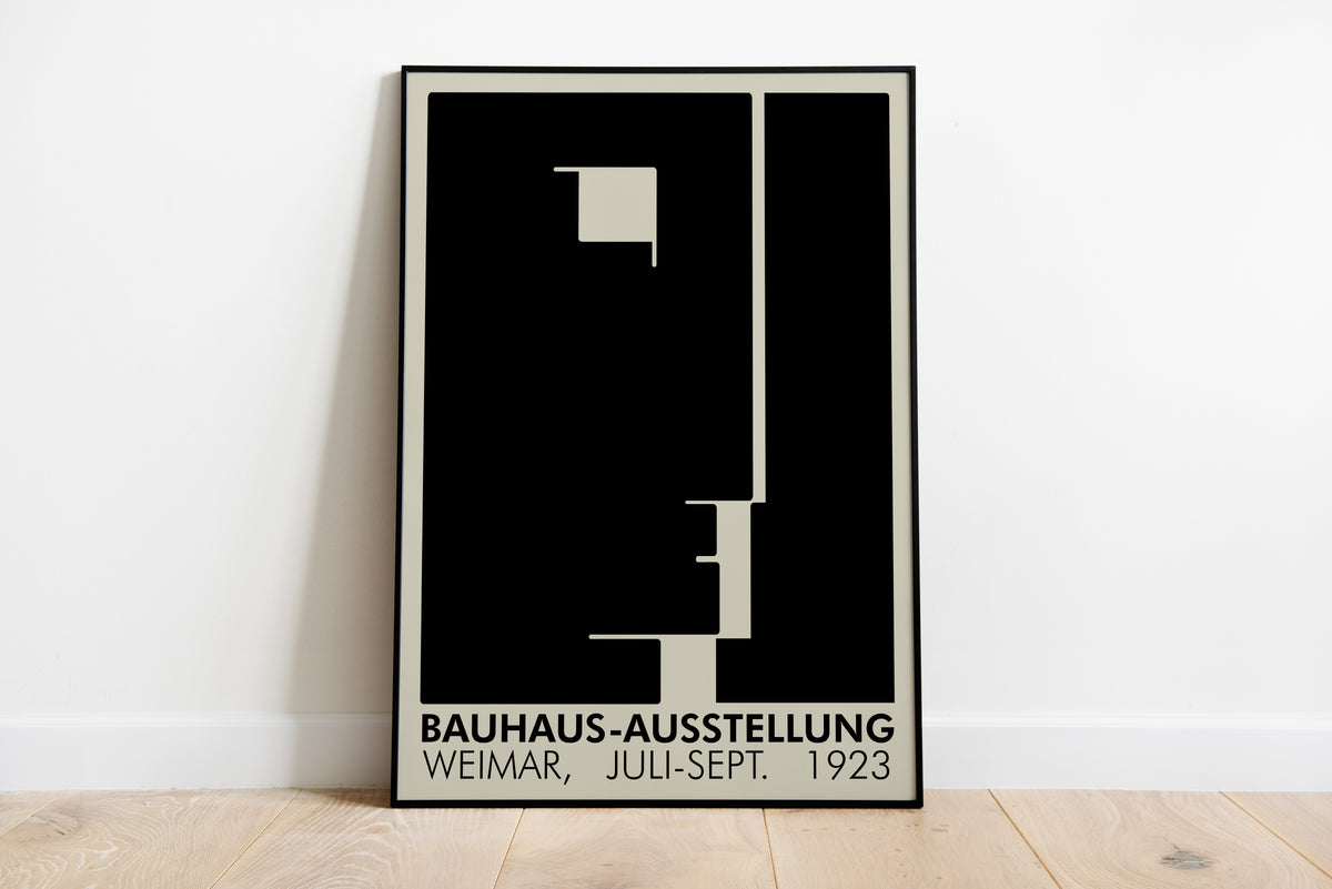 Bauhaus-Ausstellung Weimar 1923 poster leaning against a white wall on a wooden floor
