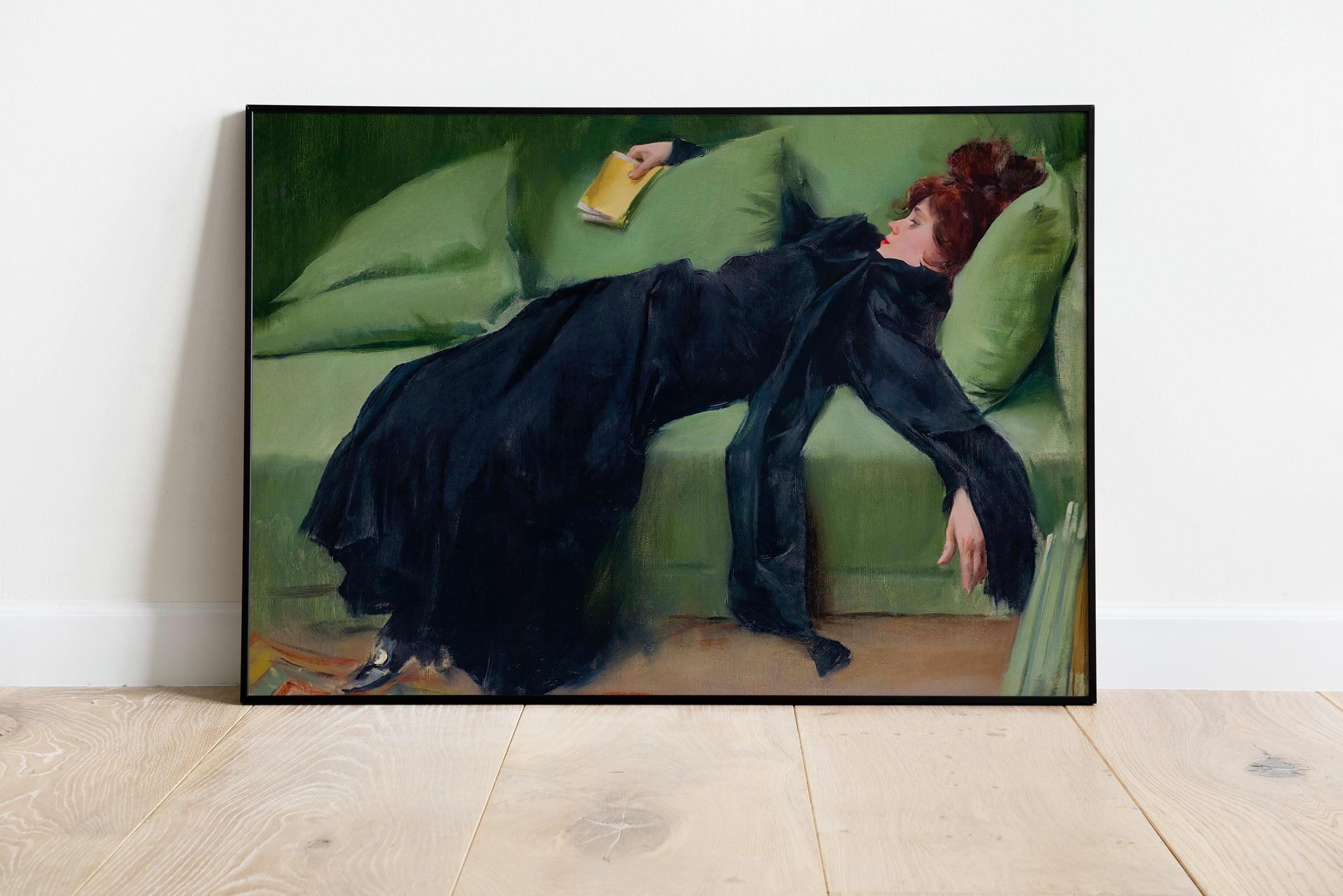 Decadent young woman painting poster with reclining figure on sofa holding book