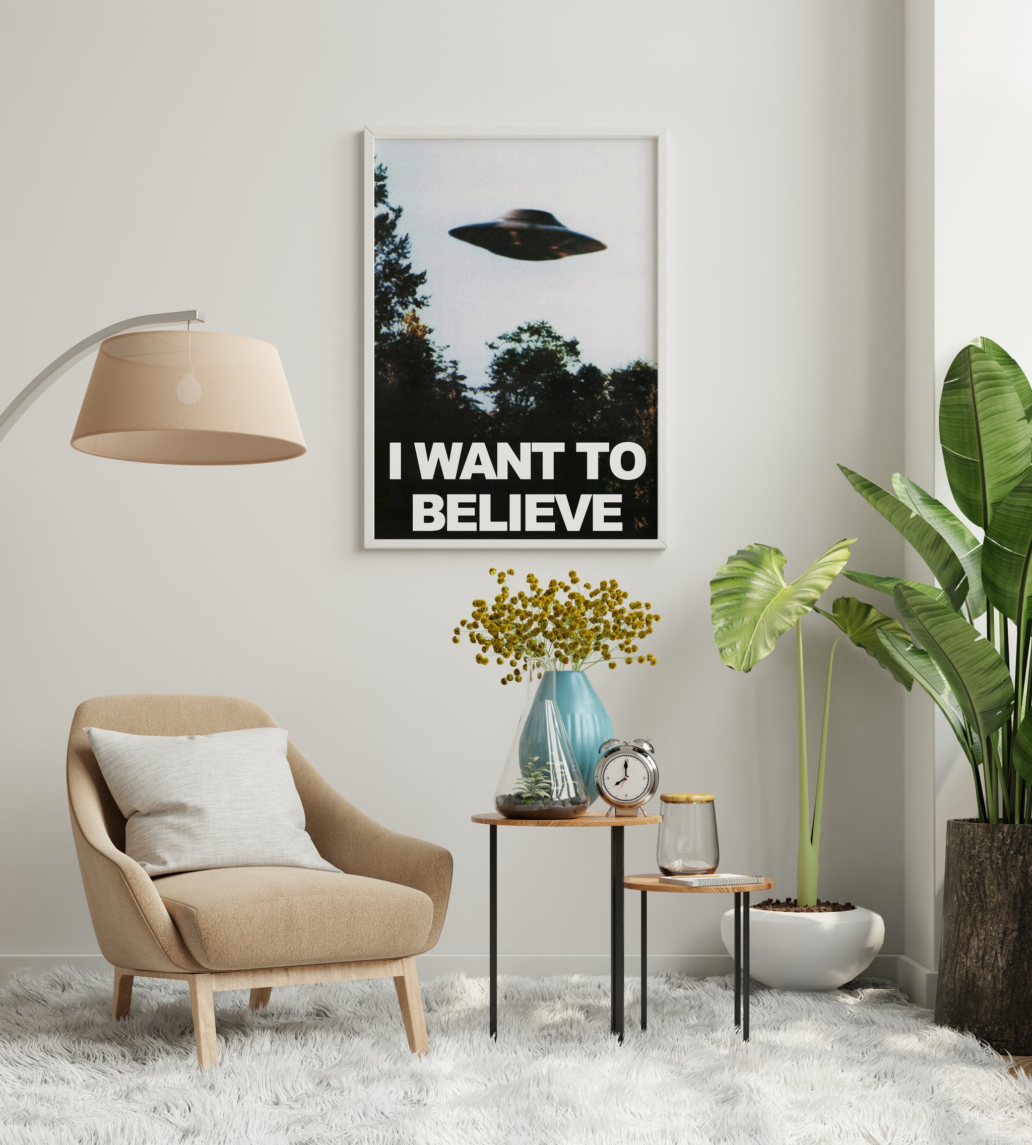 I Want to Believe print displayed on a neutral living room wall above a seating area.