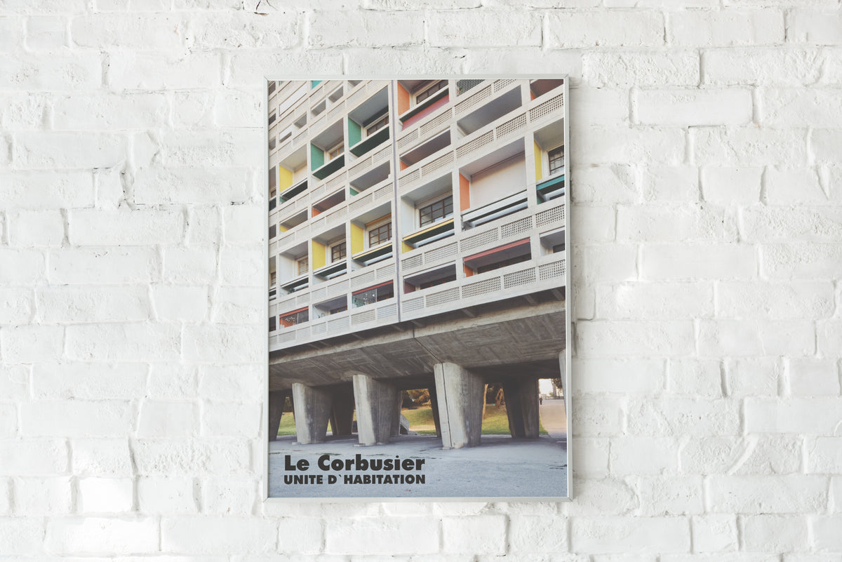 Le Corbusier Unité d'Habitation architecture poster mounted on a white brick wall.