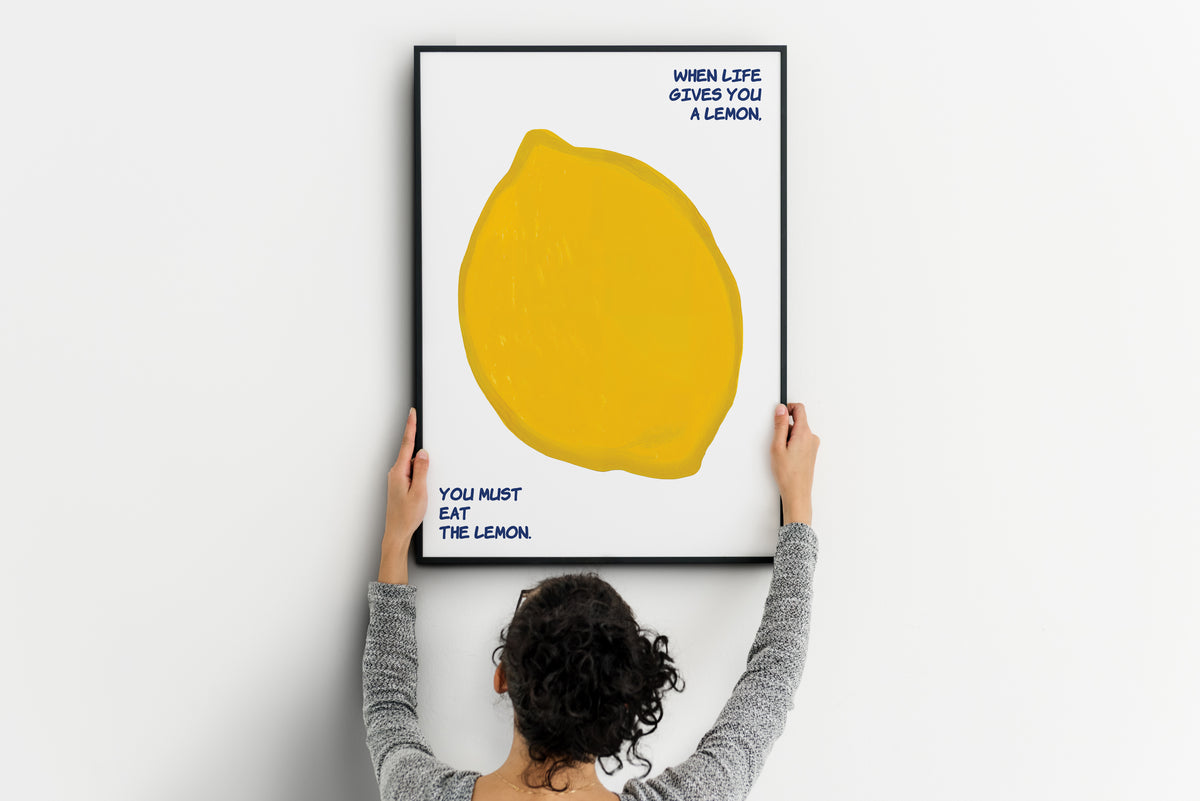 Large lemon poster with blue quote text being positioned on a wall