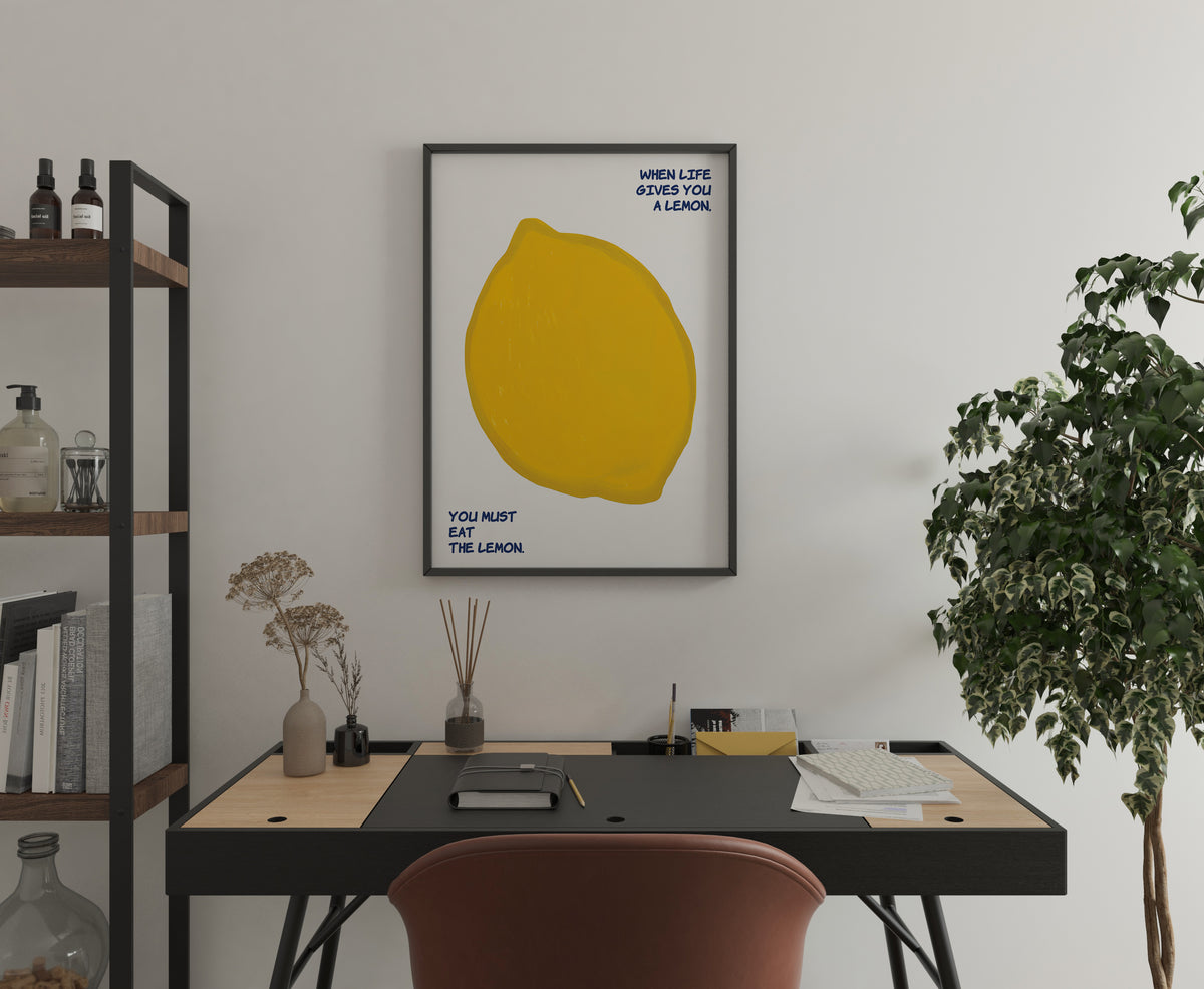 Lemon statement poster with yellow fruit illustration displayed above a home office desk