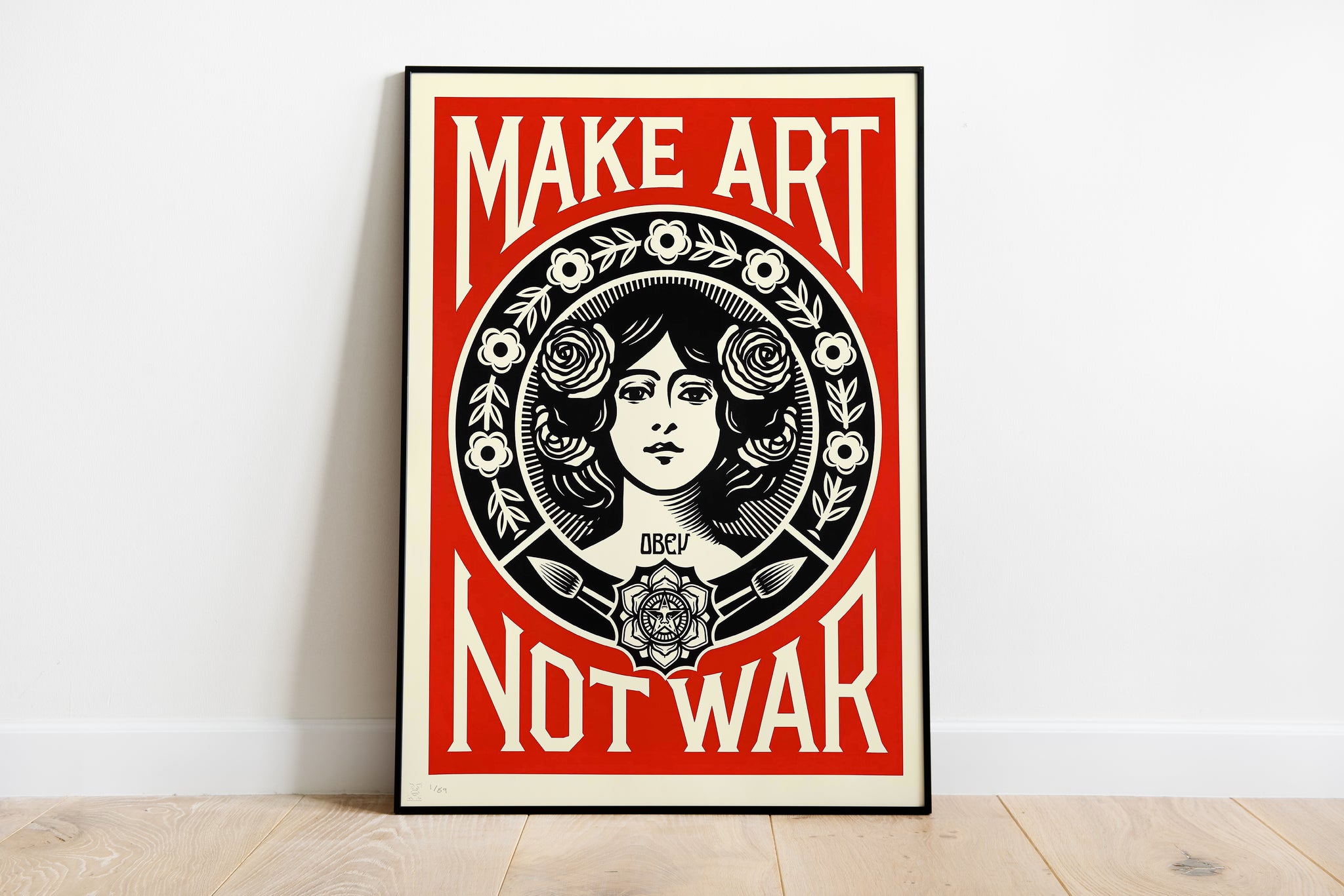 Make Art Not War poster with a floral woman portrait, paintbrushes and bold red, black and cream graphics.