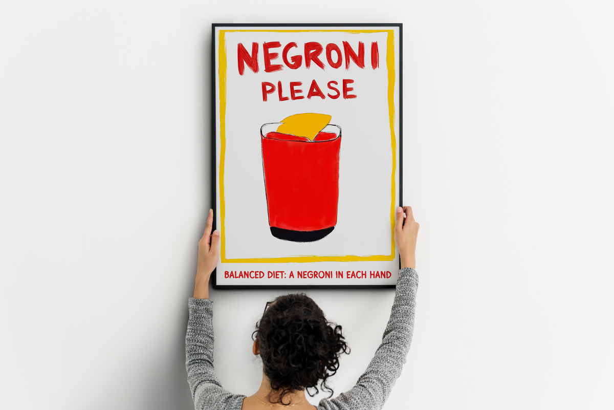 Large Negroni poster with red cocktail and humorous typography being positioned on a wall