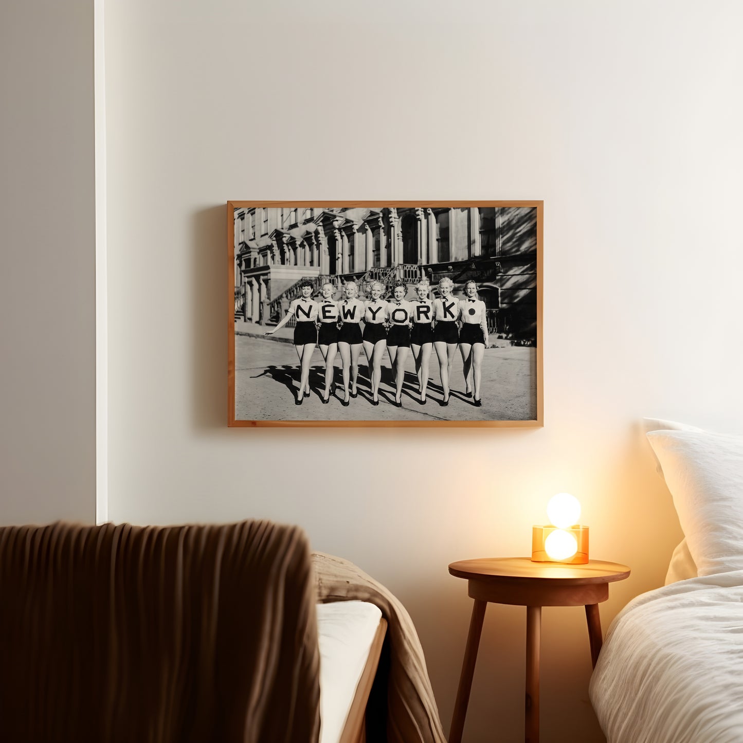Black-and-white New York print displayed on a living room wall, featuring eight women in matching outfits.