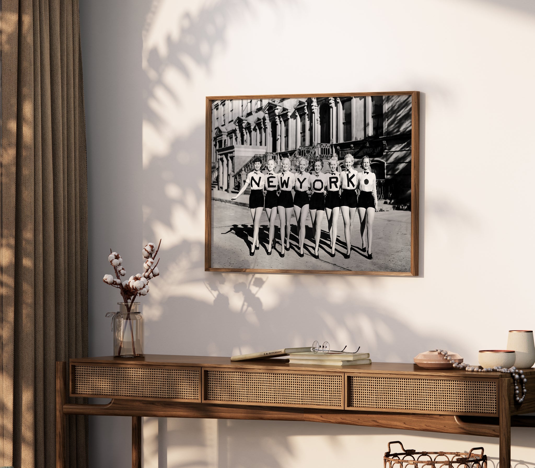 Black-and-white New York poster displayed on a living room wall with eight women spelling NEW YORK.