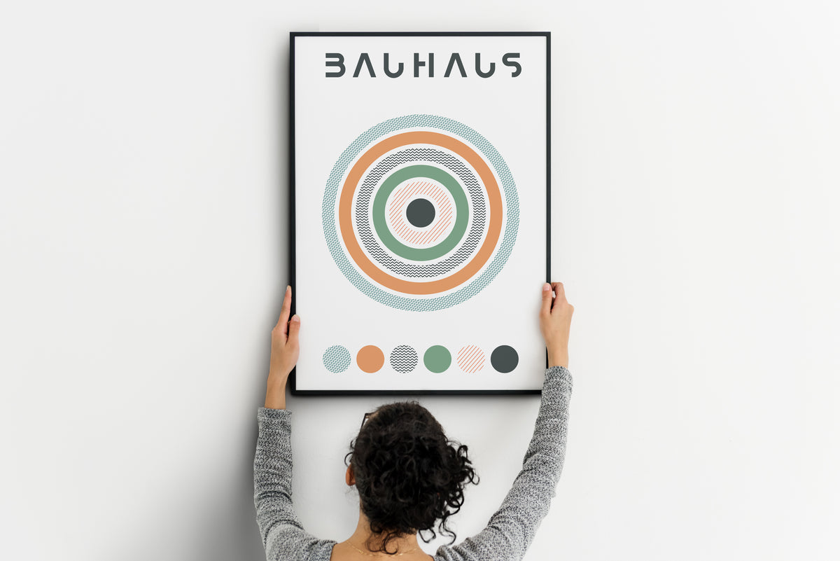 Person holding Bauhaus-inspired poster with concentric circles and color palette strip.