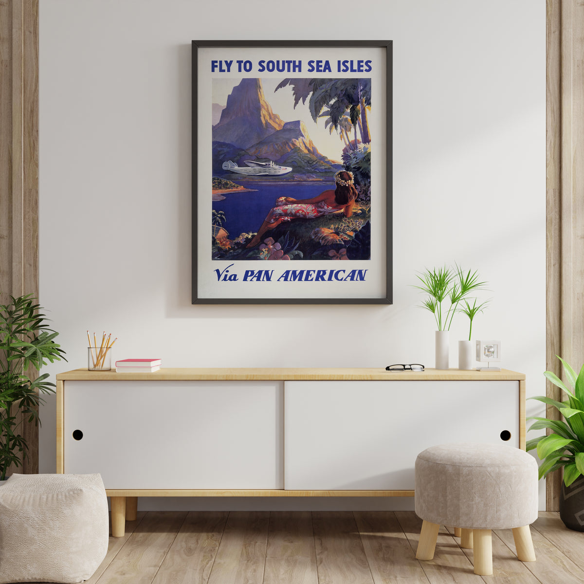 South Sea Isles Pan American poster with seaplane, lagoon and mountain scene in a living room.