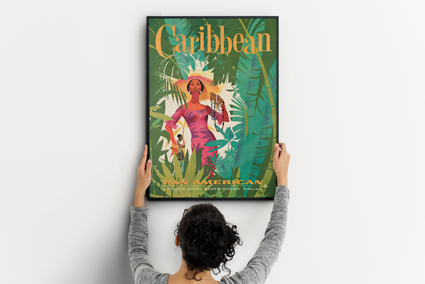 large Caribbean travel poster being placed on wall, tropical vintage print