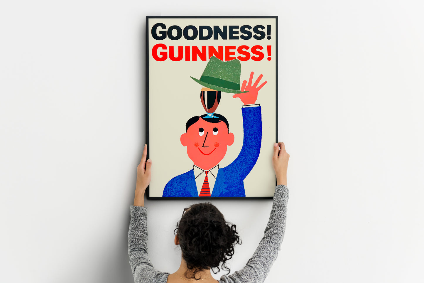 large Guinness poster being placed on wall, bold vintage beer print