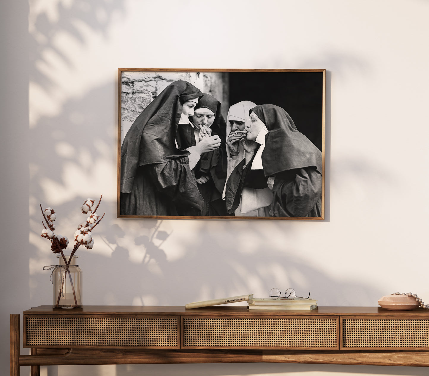 Wide room view of a smoking nuns poster with four figures in a stark monochrome composition.