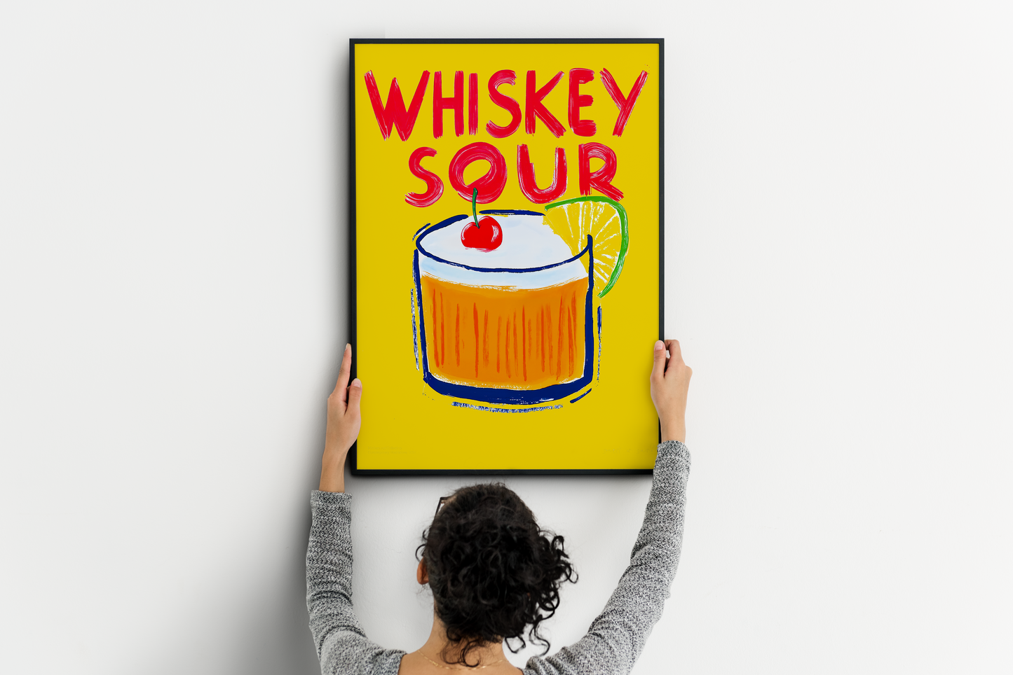 Whiskey sour print leaning against a clean white interior wall